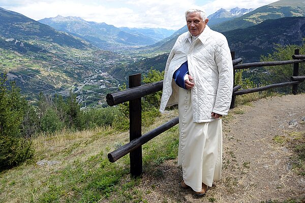 Papst Benedikt XVI. im italienischen Aosta-Tal bei Les Combes am 18. Juli 2009. Mit Blick in die Berge. Der Papst hat einen verbundenen Arm und eine Schultermanschette.